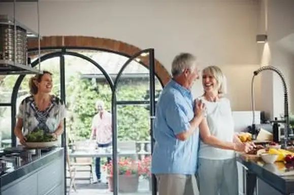 Personas mayores entreteniendo a los invitados en la cocina grande