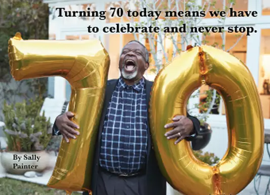 70番の風船を持って70歳になることを祝う男