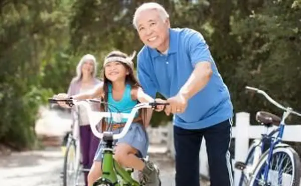aider sa petite-fille à faire du vélo