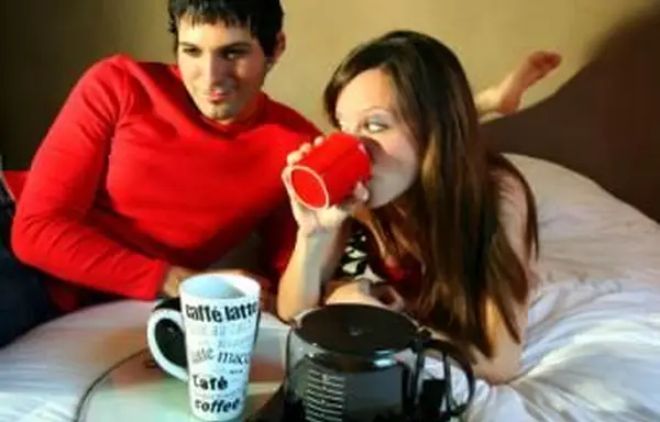 Coppia che prende un caffè a letto