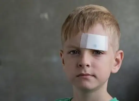 Menino com bandagem na testa