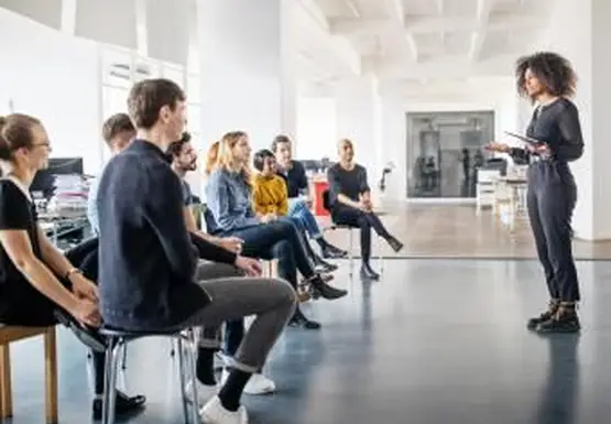 kobieta dzieląca się swoimi poglądami z zespołem podczas spotkania w biurze