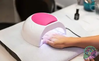 žena ruce a lampa na nehty na stole