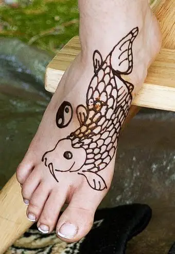 Tatuaże z rybami i ying yang pieszo