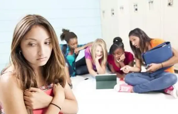 Dospievajúce dievčatá s tabletovým počítačovým šikanovaním spolužiaka