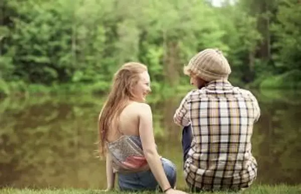 Widok z tyłu pary siedzącej w pobliżu jeziora