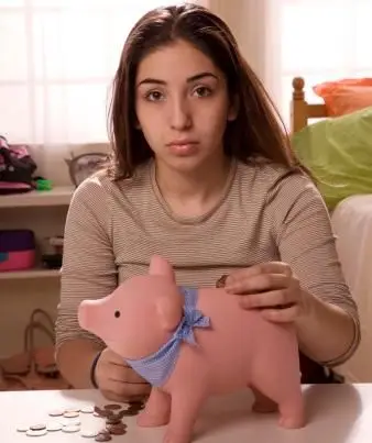 貯金箱にコインを入れるティーンエイジャー