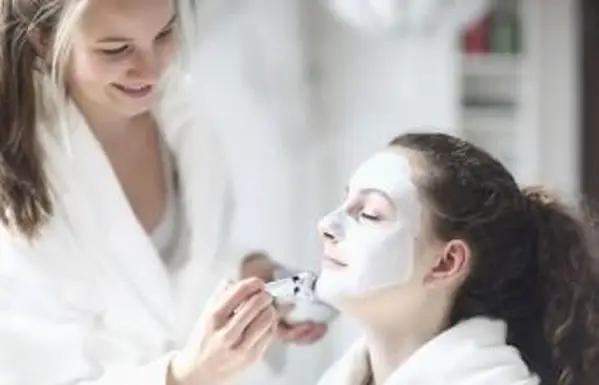 Dievča nanášajúce masku na priateľa