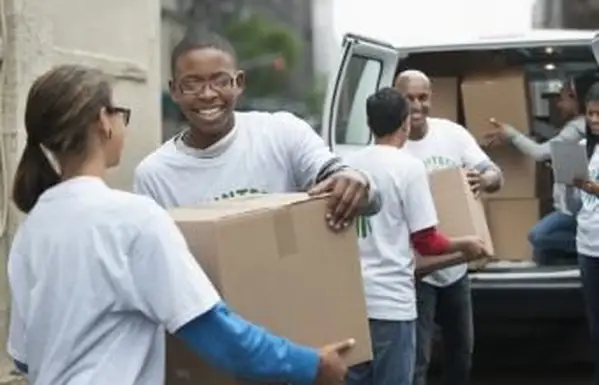 Adolescentes descarregando caixas do carro