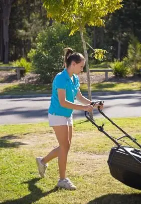 dziewczyna kosząca trawnik