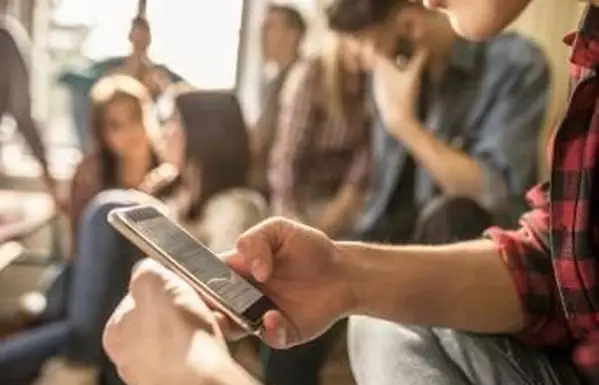 Studente che usa il cellulare durante una pausa in classe