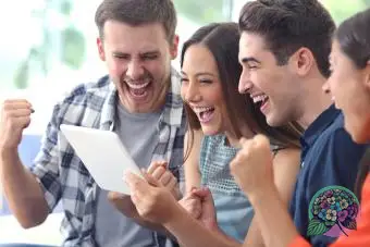 Groupe d'amis enthousiastes jouant, préféreriez-vous jouer sur tablette