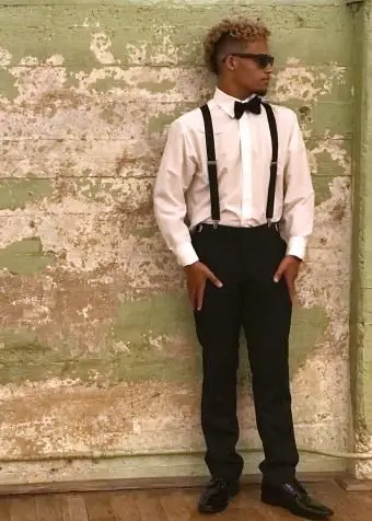 멜빵과 나비 넥타이를 착용하는 젊은 남자