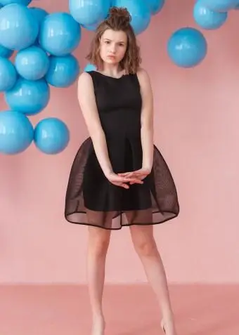 검은 칵테일 드레스를 입고 십 대 소녀