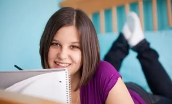 nastolatka robi dziennik na swoim łóżku