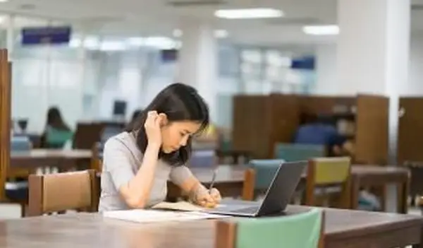 Aluno pesquisando na biblioteca