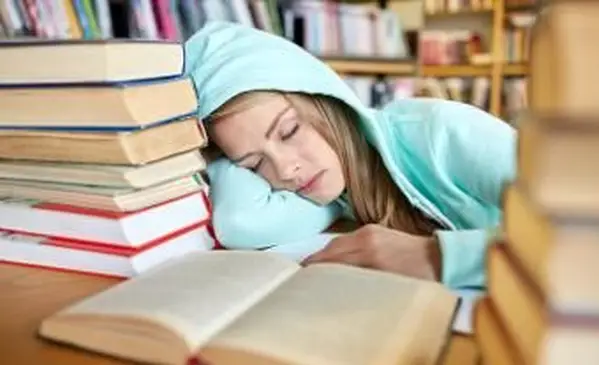 Estudiante con libros durmiendo