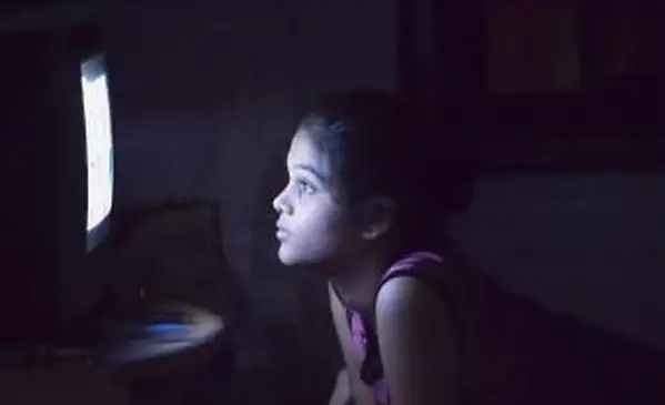 어둠 속에서 텔레비전을 시청하는 십 대 소녀