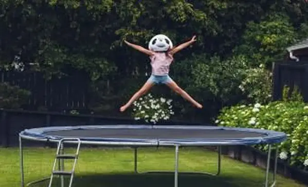 Fille portant un masque de panda sur trampoline