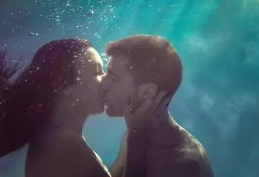 Jovem casal se beijando embaixo d'água