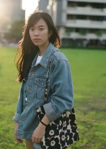 אישה אוחזת בתיק מעוצב עם פרחים