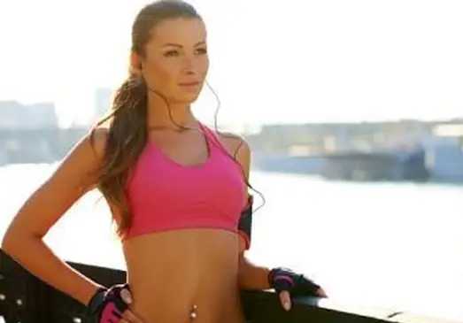 Menina com piercing no umbigo