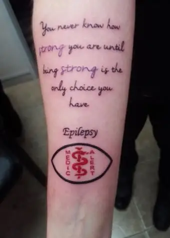 Tatuaggio di allerta per l'epilessia e citazione sulla forza