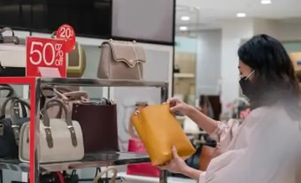 Mujer comprobando un bolso de cuero en venta