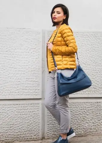 Mujer sosteniendo bolsa de mensajero azul