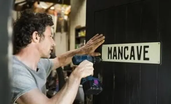 남자 나무 문에 mancave 기호를 고정