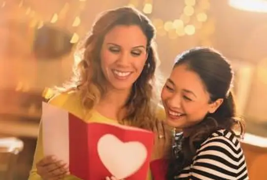 Liebevolles lesbisches Paar mit Valentinstagskarte