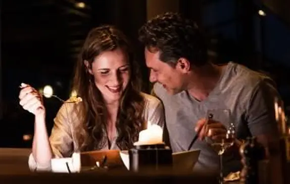 家でロマンチックな夕食を食べているカップル