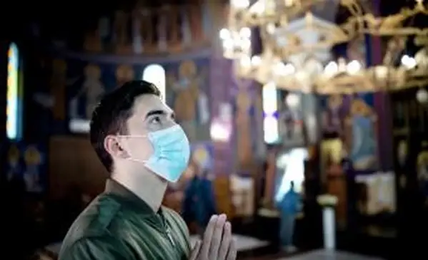 Młody mężczyzna w masce ochronnej w kościele