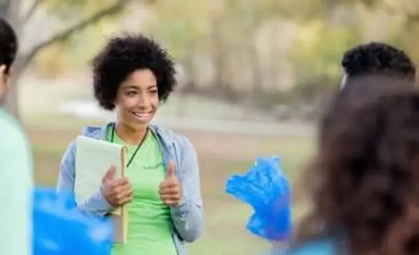 Mladá žena organizuje dobrovoľníkov v oblasti očistenia komunity