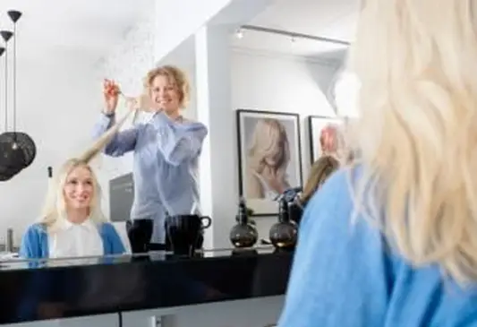 Cabeleireiro cortando cabelo de mulher