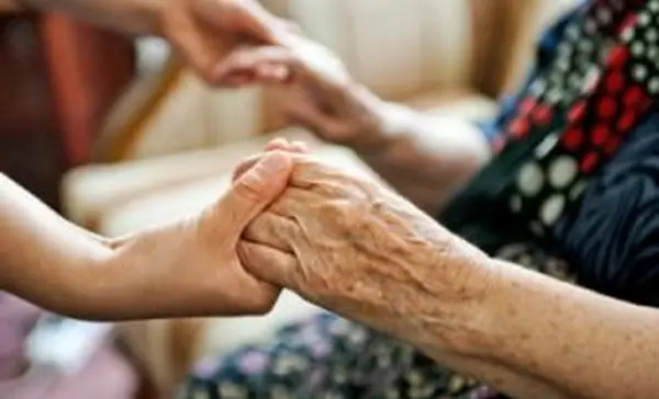 Volontariato che tiene una persona anziana