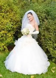 Noiva posando em frente a sebes em um casamento no quintal