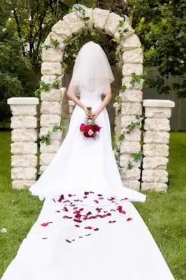 La sposa indossa un abito da sposa bianco sotto l'arco