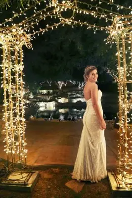 Sposa in piedi sotto l'arco con le luci