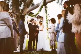 Giovani sposi che si sposano e si scambiano gli anelli all'aperto