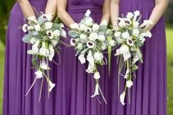 Trois demoiselles d'honneur tenant des bouquets de mariage