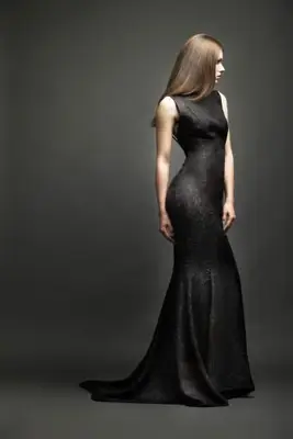 Muž v obleku tancuje s blond ženou v čiernych večerných šatách na piesočnatej pláži