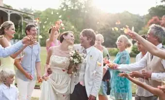 Invités jetant des pétales de rose sur les mariés