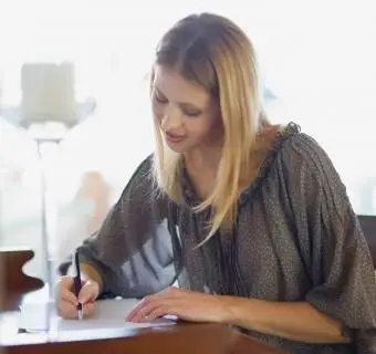 Menina escrevendo um cartão