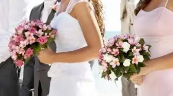 Mariée et demoiselle d'honneur tenant de beaux bouquets de frangipanier