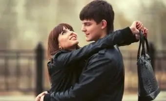 革製の財布を持っている夫を抱きしめる女性