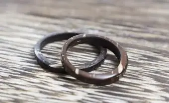 Coppia unica di anelli di cocco fatti a mano su fondo in legno