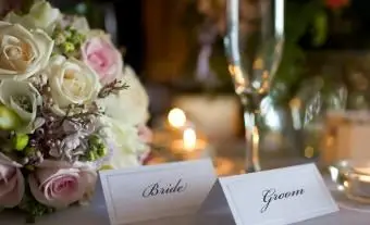 Cartes de place des mariés avec bouquet à la réception de mariage