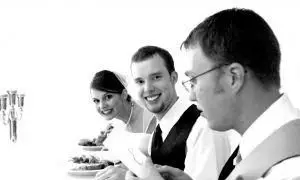 Noiva, noivo e padrinho jantando