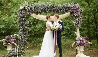 Państwo młodzi w pobliżu łuku bzu